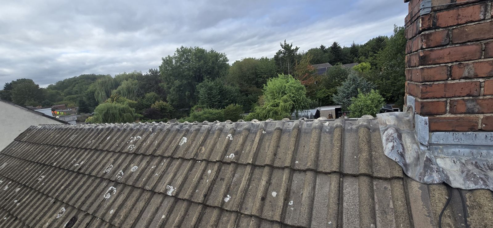 Ridge line prepped for a dry ridge system, chimney lead flashing visible