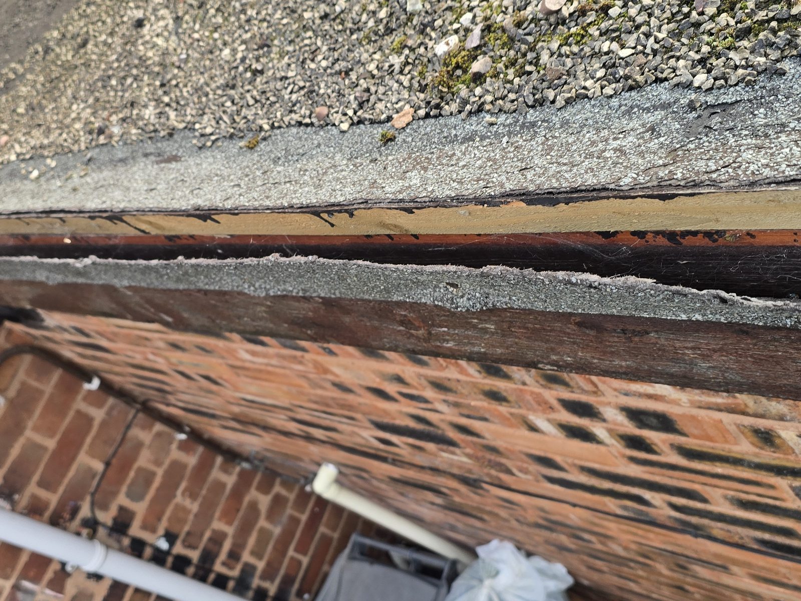 Felt drip edge come away from the edge of a flat roof, exposing the timber beneath