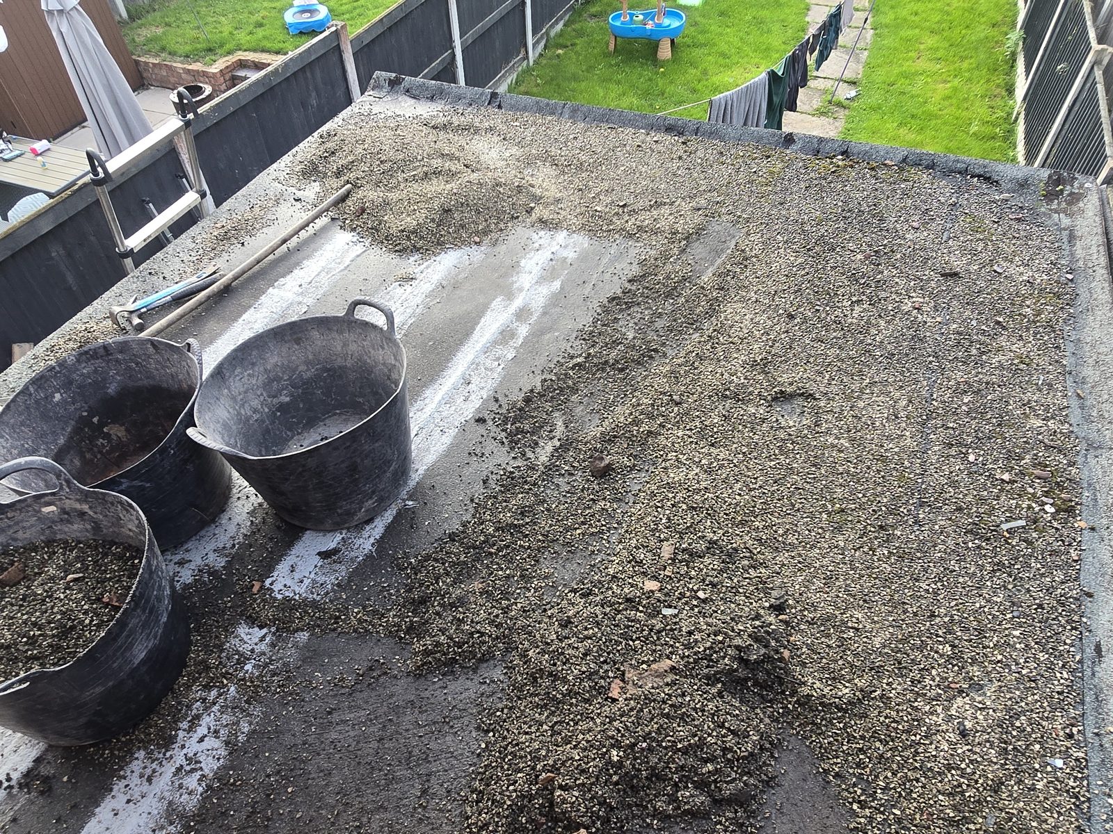 Leaking felt flat roof covered in stone chippings on an extension in Connah's Quay before replacement