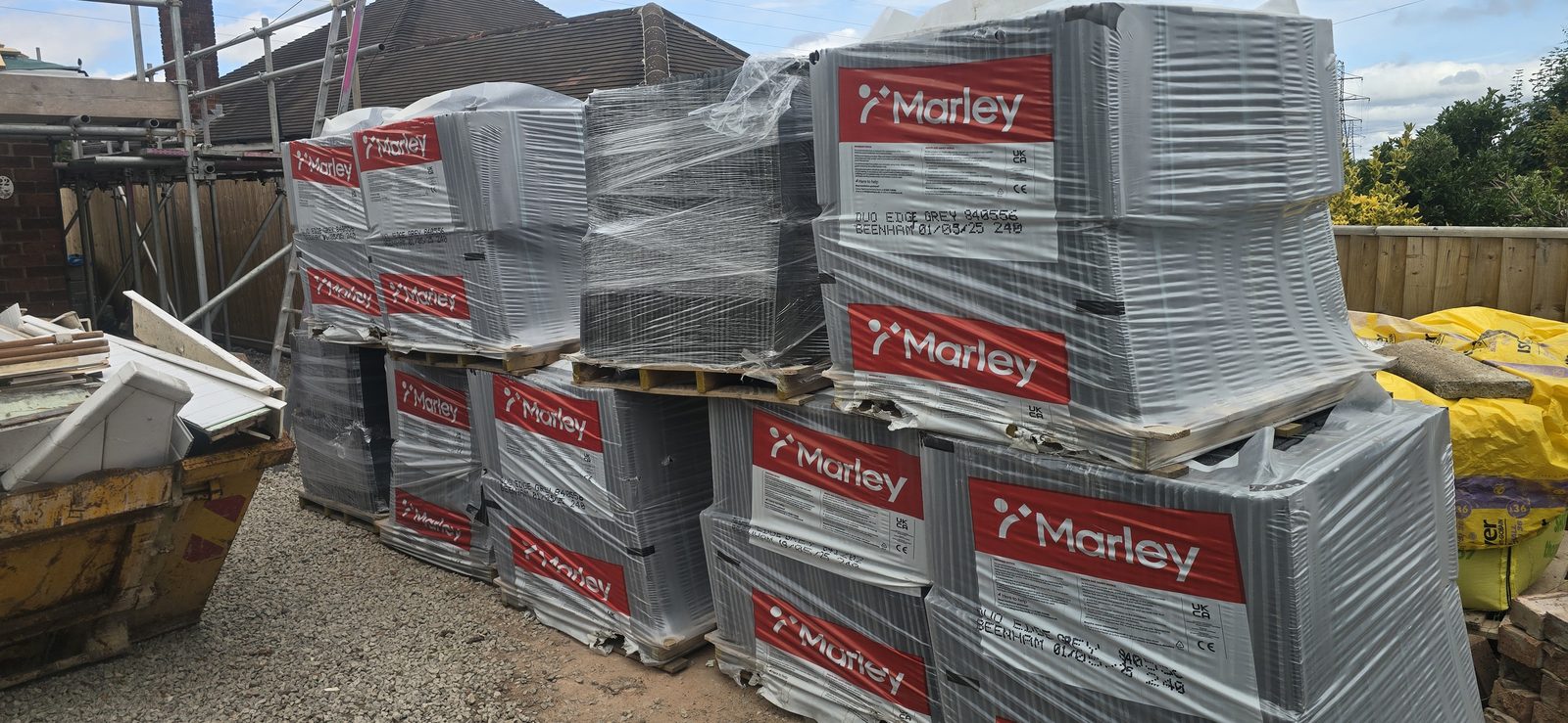 Pallets of Marley Duo Edgemere grey roof tiles delivered to site in Hawarden