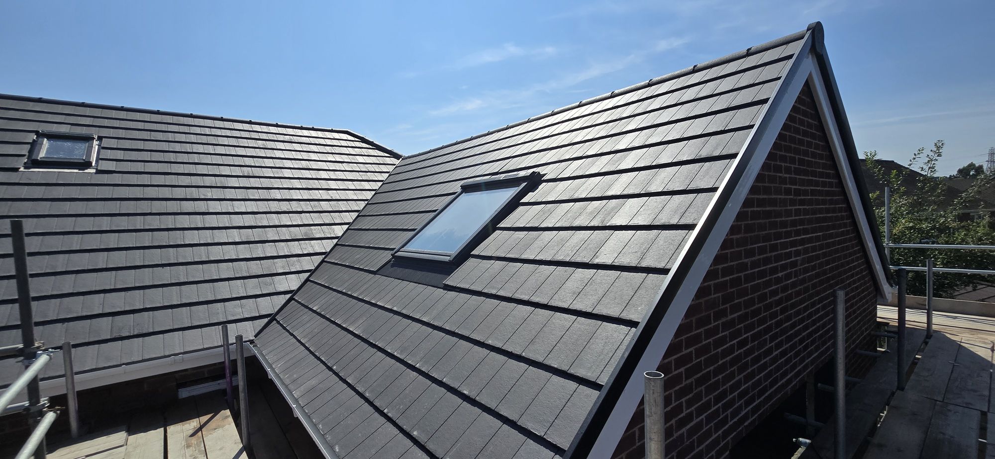 Completed grey tiled roof with roof window fitted by LSE Roofing