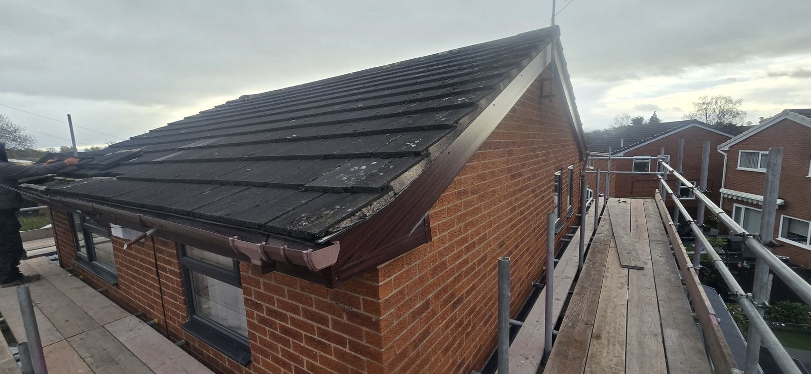 Dated brown UPVC fascias, soffits and guttering on a property in Wrexham before replacement