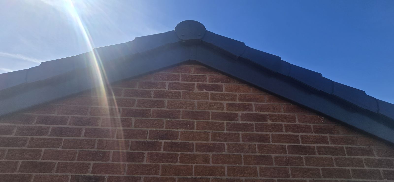 Completed anthracite fascia and dry verge at the gable apex in Wrexham