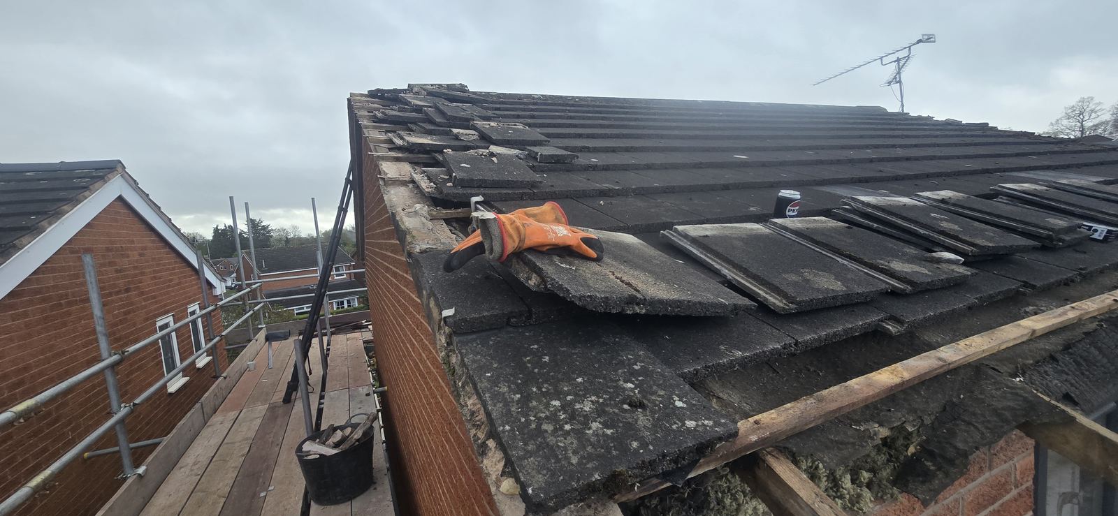Mortar-bedded verge tiles stripped back on the gable end ready for a dry verge system in Wrexham
